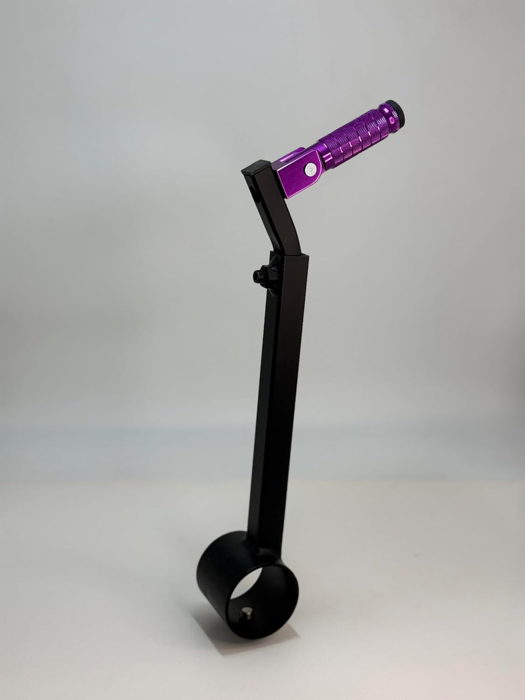 The purple Potter's Peg pottery wheel attachment, a black powder coated peg with a knurled grip mounted on an adjustable leg clamp