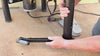 Potter installing The Potter's Peg on an electric pottery wheel leg, then resting a foot on the peg while throwing clay